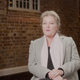 Kate Mulgrew wears a scarf and blazer, with a Starfleet uniform on a mannequin behind her.